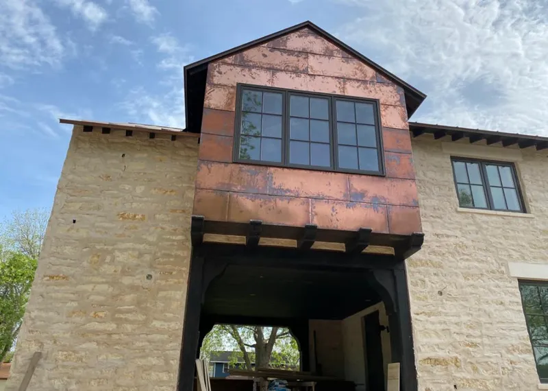 Copper metal panel facade on a stone building for Skylight Installation in Samsula-Spruce Creek
