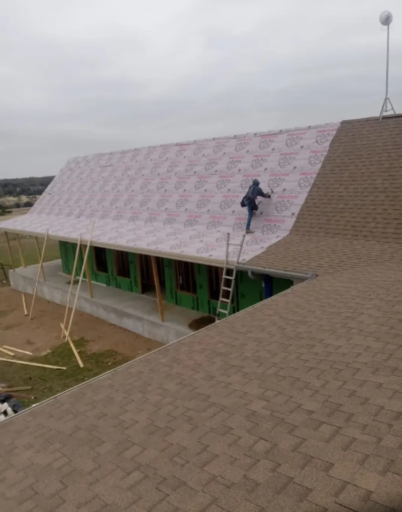 Worker preparing underlayment for a metal roof installation in Samsula-Spruce Creek